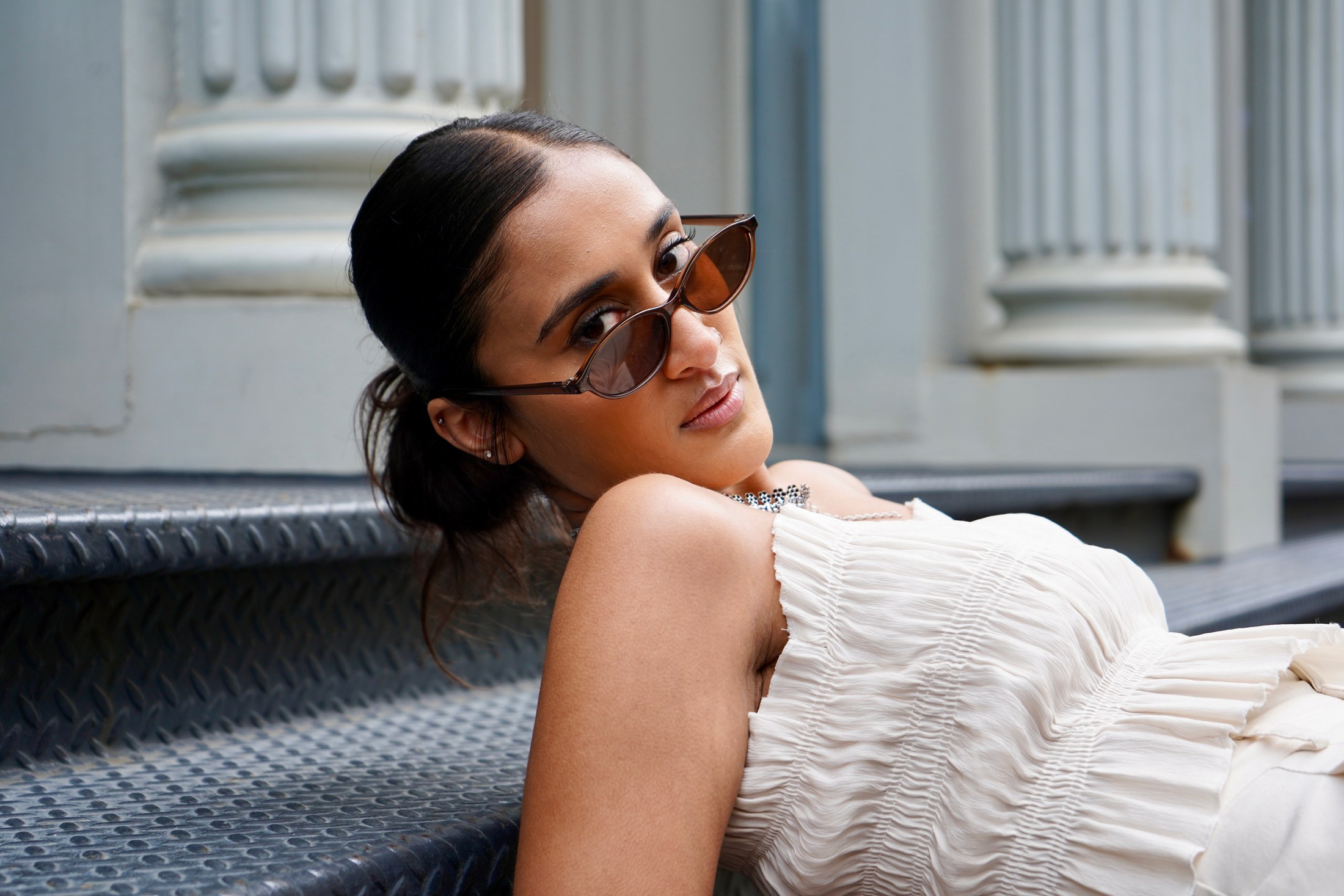 Raagini Gupta reclining on city steps in an editorial portrait