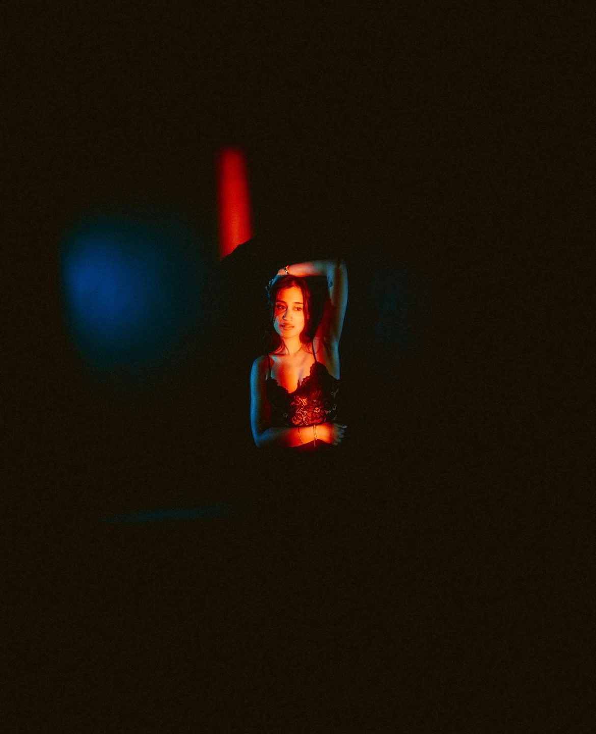 Raagini Gupta looking toward camera in red and blue editorial lighting